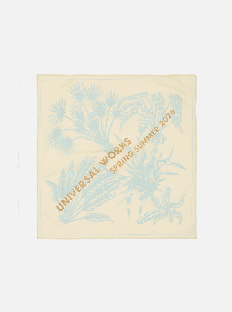 The Cream Cambric Neckerchief is displayed as a flat lay against a plain white background. The square accessory features an exclusive dark-colored graphic print across the cream cotton fabric.