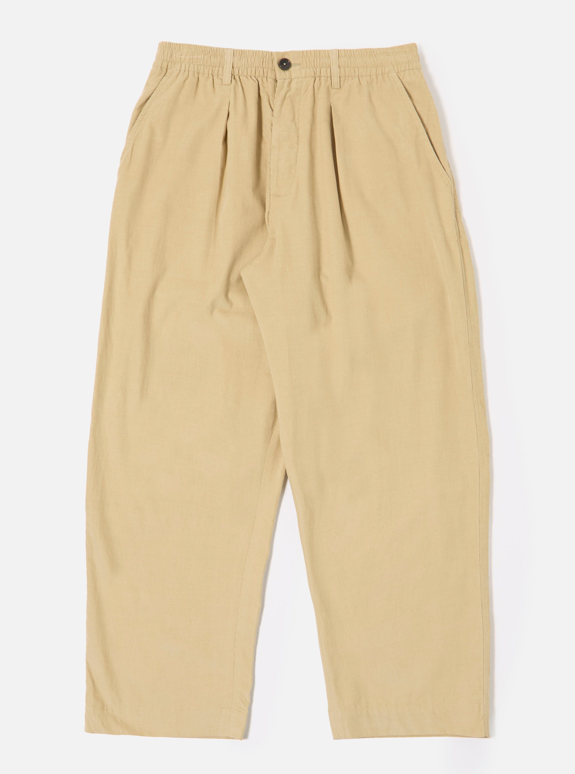 The Sand Organic Fine Cord Oxford Pant is shown as a flat lay against a white background. The trousers feature a wide, loose leg with a single pleat front and an elasticated waistband with a tonal drawstring. The fabric has a fine corduroy texture in a light sand color.