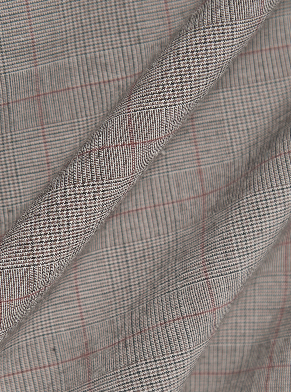 The Grey Brown Wales Glen Check Franck Jacket is shown in a detail view as a flat lay against a plain white background. The image highlights the intricate grey and brown glen check pattern of the cotton fabric and the construction of the garment's functional pockets and clean stitching.