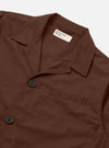 The Brown Peached Poplin Franck Jacket is shown from the back as a flat lay against a plain white background. The image highlights the smooth, brown peached poplin fabric and the clean construction of the garment's rear, featuring a simple straight hem and a structured collar visible at the top.