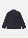The Navy Peached Poplin Franck Jacket is shown as a flat lay against a plain white background. This short-cut chore jacket features a one-piece flat collar, a central button-down closure, two front flap pockets at the waist, and a single welt pocket on the chest. The navy blue cotton fabric has a smooth, peached poplin finish.