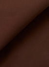 A close-up swatch image of the Brown Peached Poplin Military Chino fabric highlights the solid brown color and the smooth, matte finish of the peached poplin material. The textile's fine weave is clearly visible.