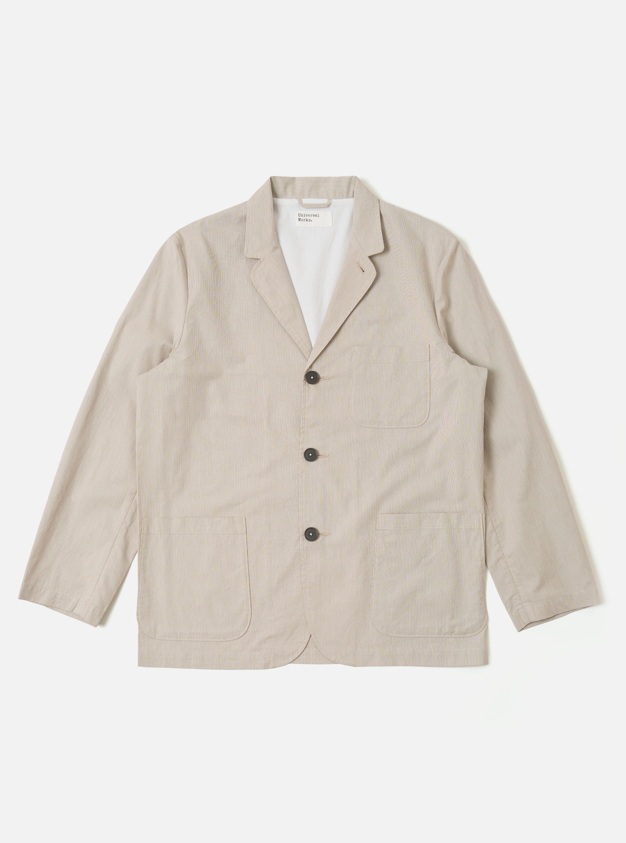 The Brown Kennedy Stripe Three Button Jacket is presented as a flat lay against a plain white background. The jacket features a classic three-button front closure, a notched lapel, and three front patch pockets, including one at the chest and two at the waist. The fabric is a brown cotton with a visible vertical stripe pattern.
