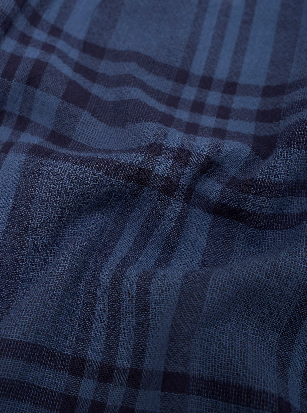 Close-up of blue plaid fabric with a focus on texture and pattern.