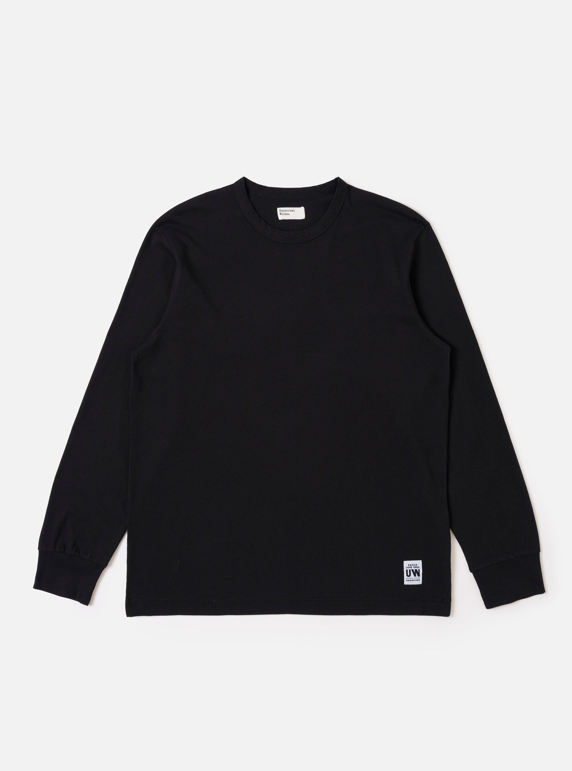 The Black Recycled/Bio Jersey Henry L/S Tee is presented as a flat lay against a plain white background. This long-sleeve t-shirt features a crew neckline, ribbed cuffs, and a straight hem. The garment is made from a solid black recycled and organic cotton jersey fabric.