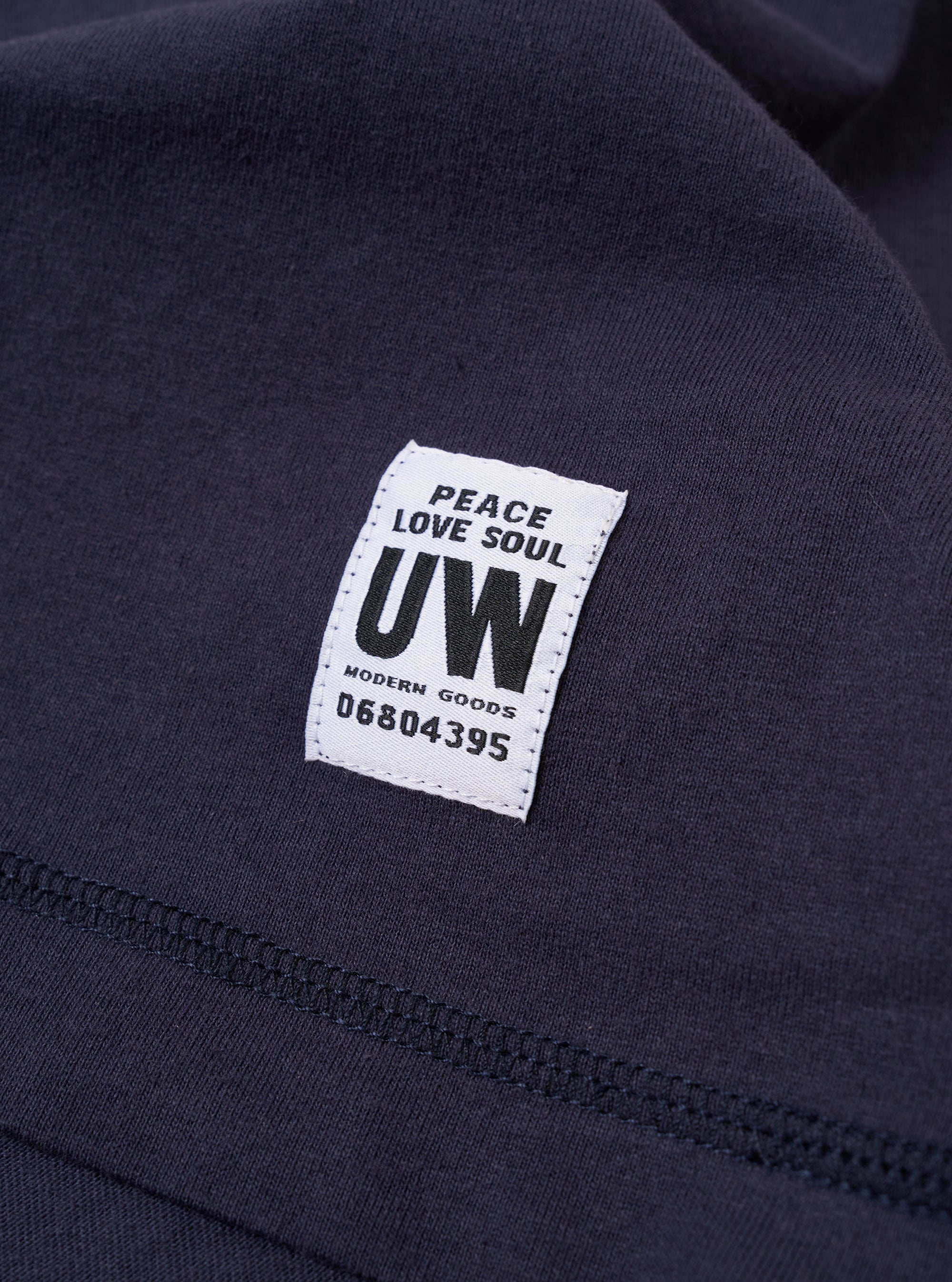 The Navy Recycled/Bio Jersey Henry L/S Tee is shown from the back as a flat lay against a plain white background. The long-sleeve t-shirt features a ribbed crew neckline and a straight hem. The dark navy blue jersey fabric has a smooth, uniform appearance.