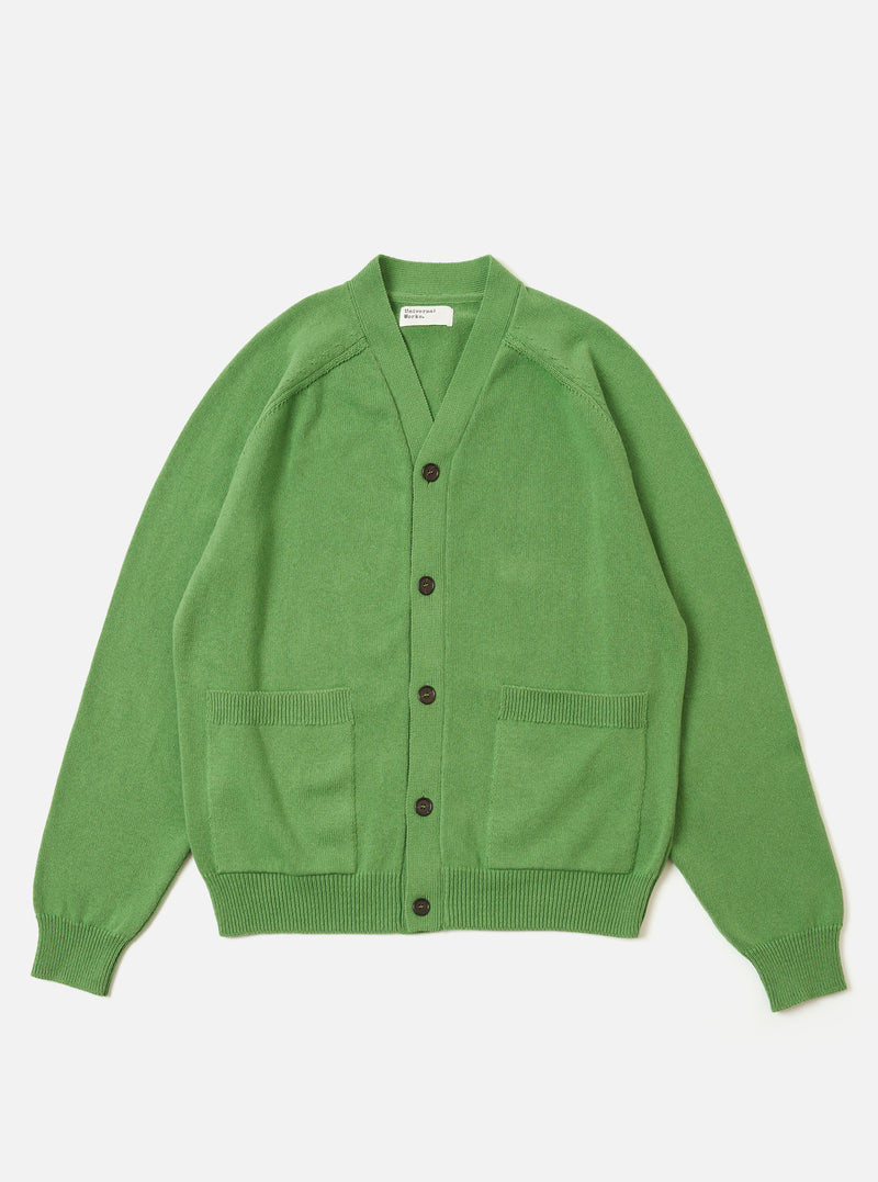The Green Eco Cotton Knit Pocket David Cardigan is shown as a flat lay against a white background. The cardigan features a chunky knit texture, raglan sleeves, a five-button front closure, and two large patch pockets at the waist. It is finished with ribbed detailing at the cuffs and hem.