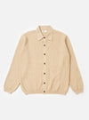 The Sand Eco Cotton Knit Jacket is presented as a flat lay against a white background. The jacket features a full button front, a structured collar, and a large square patch pocket on the left chest. It is designed with a loose fit and finished with rib trims at the cuffs and hem.