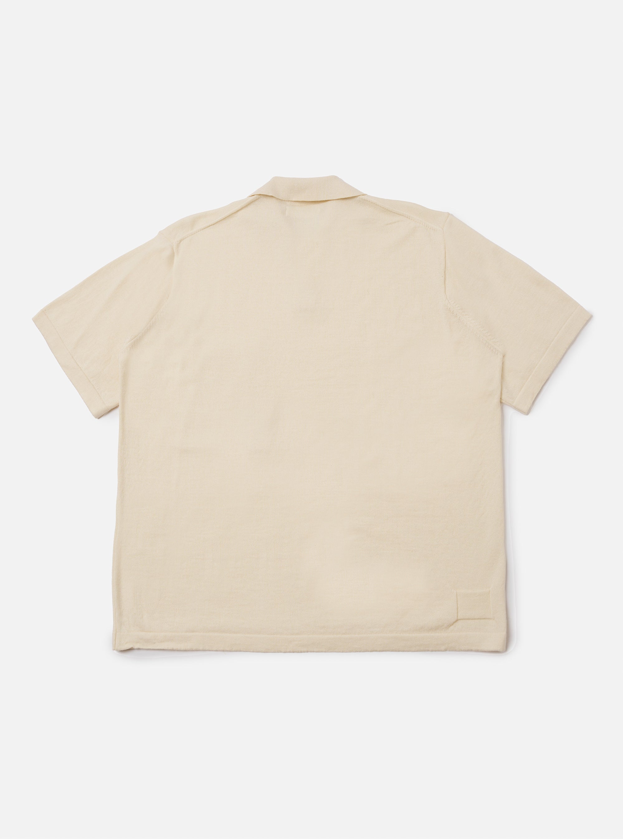 The Ecru Woolcot Bio S/S Pullover Knit Shirt II is shown from the back as a flat lay against a plain white background. The image highlights the shirt's smooth ecru-colored knit fabric, boxy fit, and short sleeves.