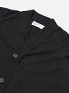 The Black Woolcot Bio Loose Cardigan II is shown from the back as a flat lay against a plain white background. The image highlights the garment's relaxed fit, dropped shoulders, and a simple straight hem. The knit fabric appears soft and uniform in a solid black color.