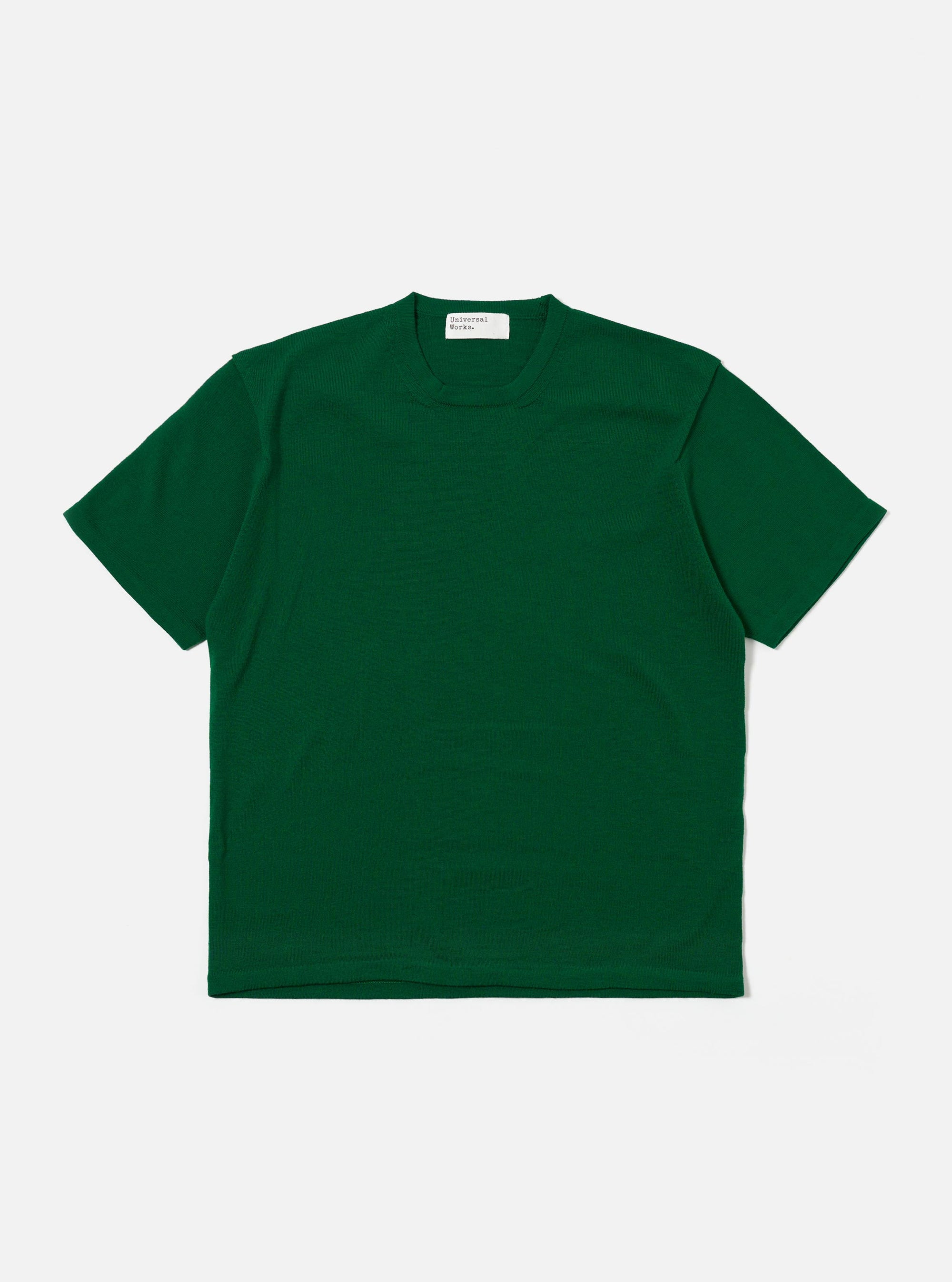 The Green Merino Fine Knit Knit Tee is shown as a flat lay against a white background. The short-sleeved t-shirt features a fine-gauge knit texture with a high crew neck and ribbed detailing at the neckline, cuffs, and hem.