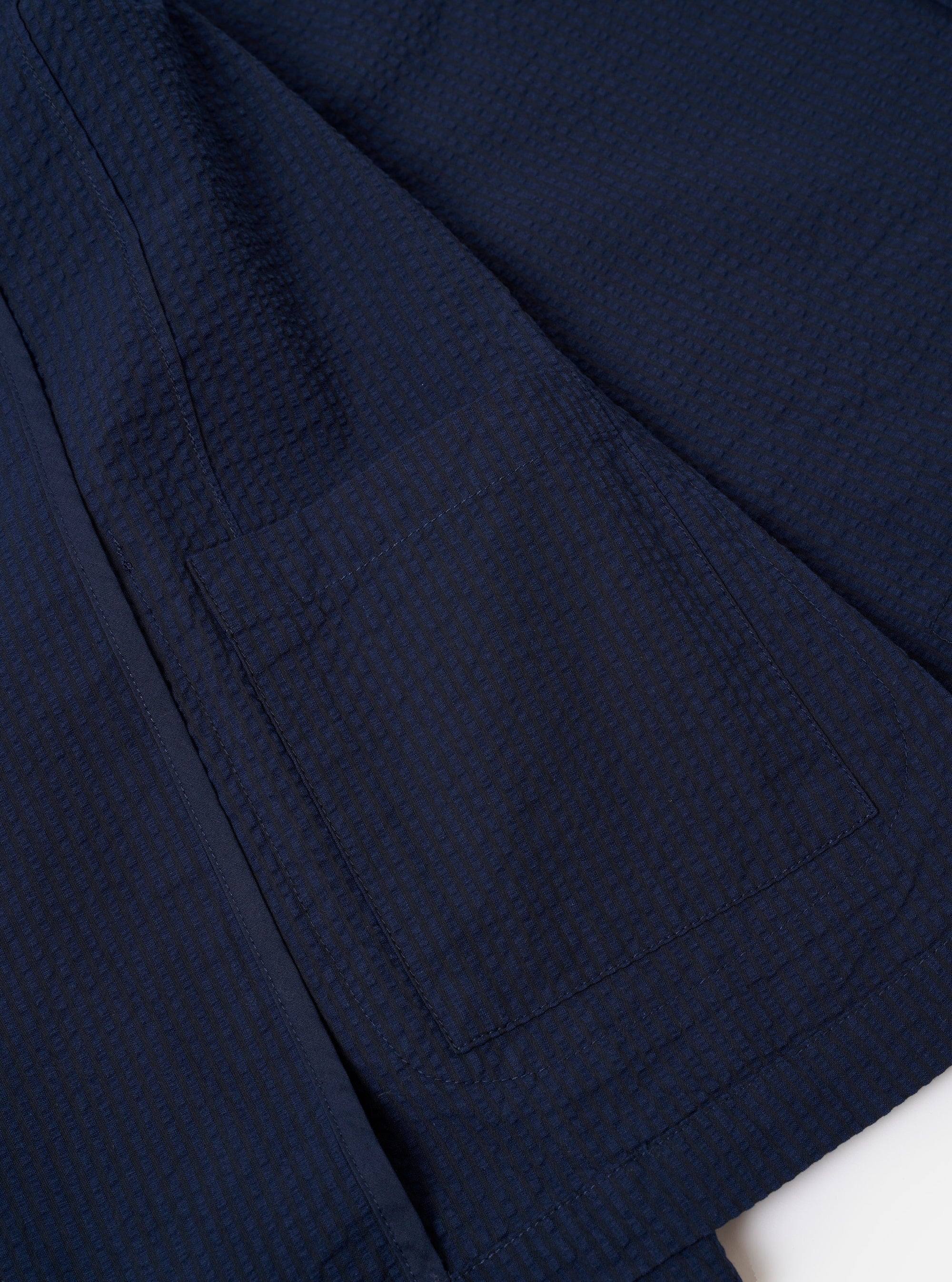 The Navy Derby Stripe Two Button Jacket is presented as a flat lay against a plain white background. The jacket features a vertical stripe pattern throughout and is shown from the back, highlighting the clean construction, shoulder seams, and central back seam.