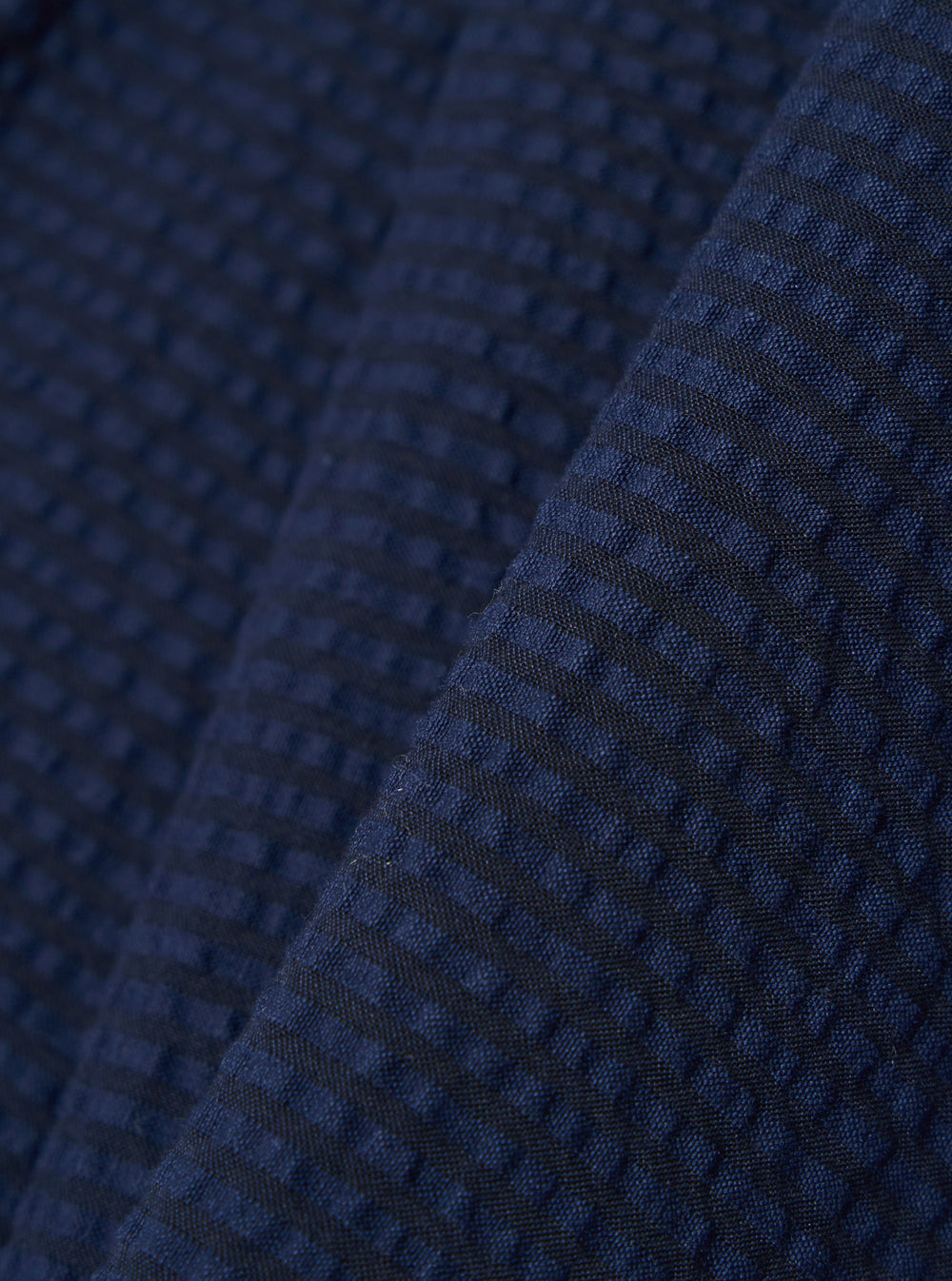 A close-up swatch image of the Navy Derby Stripe Military Chino fabric highlights the navy blue color and the distinct puckered texture of the seersucker material. The pattern features a subtle pinstripe design.