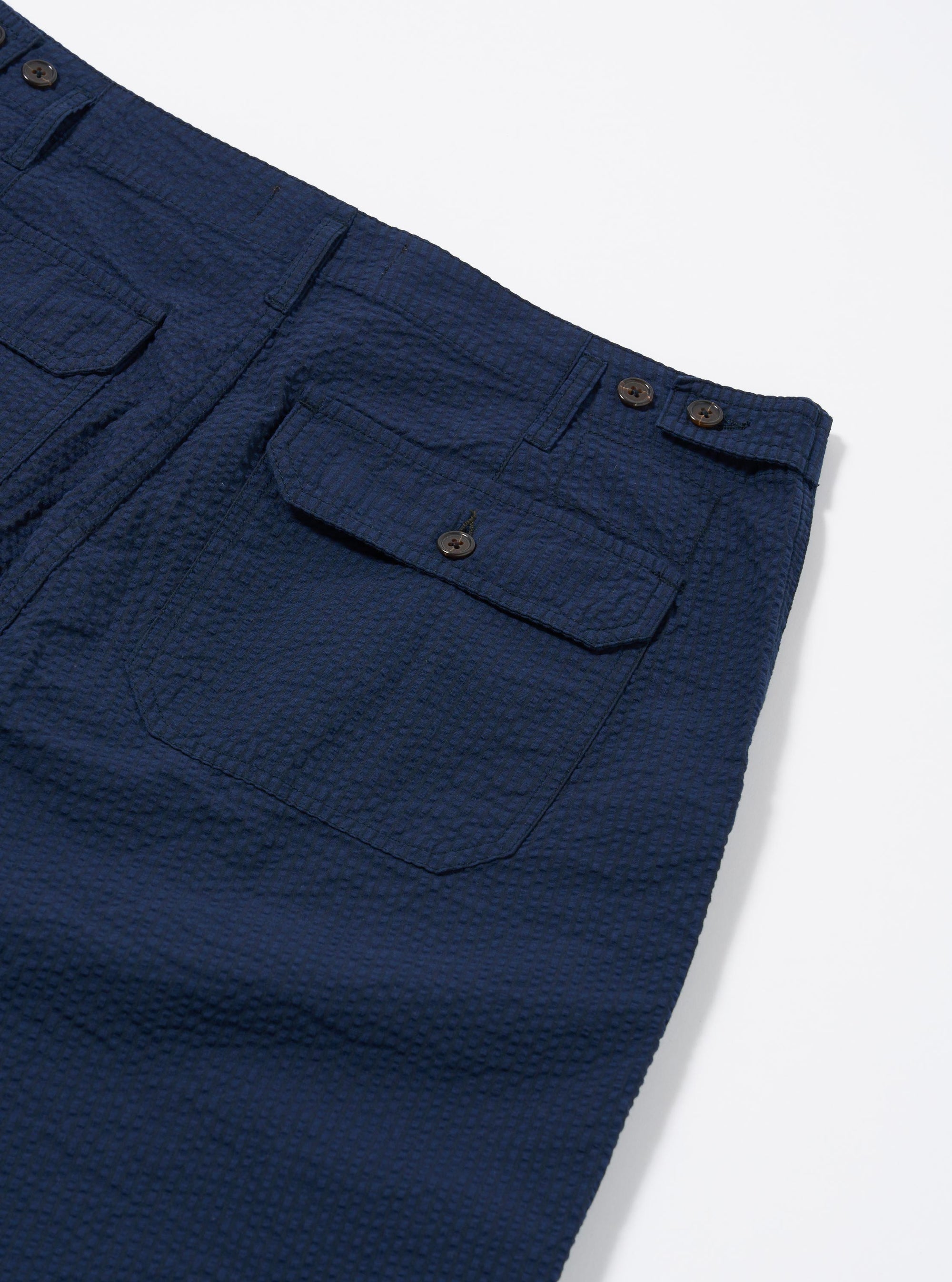 The Navy Derby Stripe Clean Short is shown from the back as a flat lay against a plain white background. The shorts feature a vertical navy and white stripe pattern, an elasticated waistband, and a single rear patch pocket on the right side. The fabric is a crisp cotton with a visible vertical stripe texture.