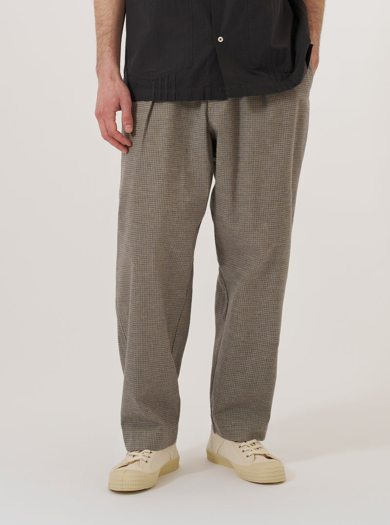 A model wears the Multi Lucas Cotton Mix Oxford Pant against a plain white background. The pants feature a multi-colored check pattern, a wide-leg fit with a slight taper, and a single pleat at the front. The model is shown from the waist down, highlighting the elasticated waistband with a drawstring and the relaxed silhouette of the cotton-mix fabric.