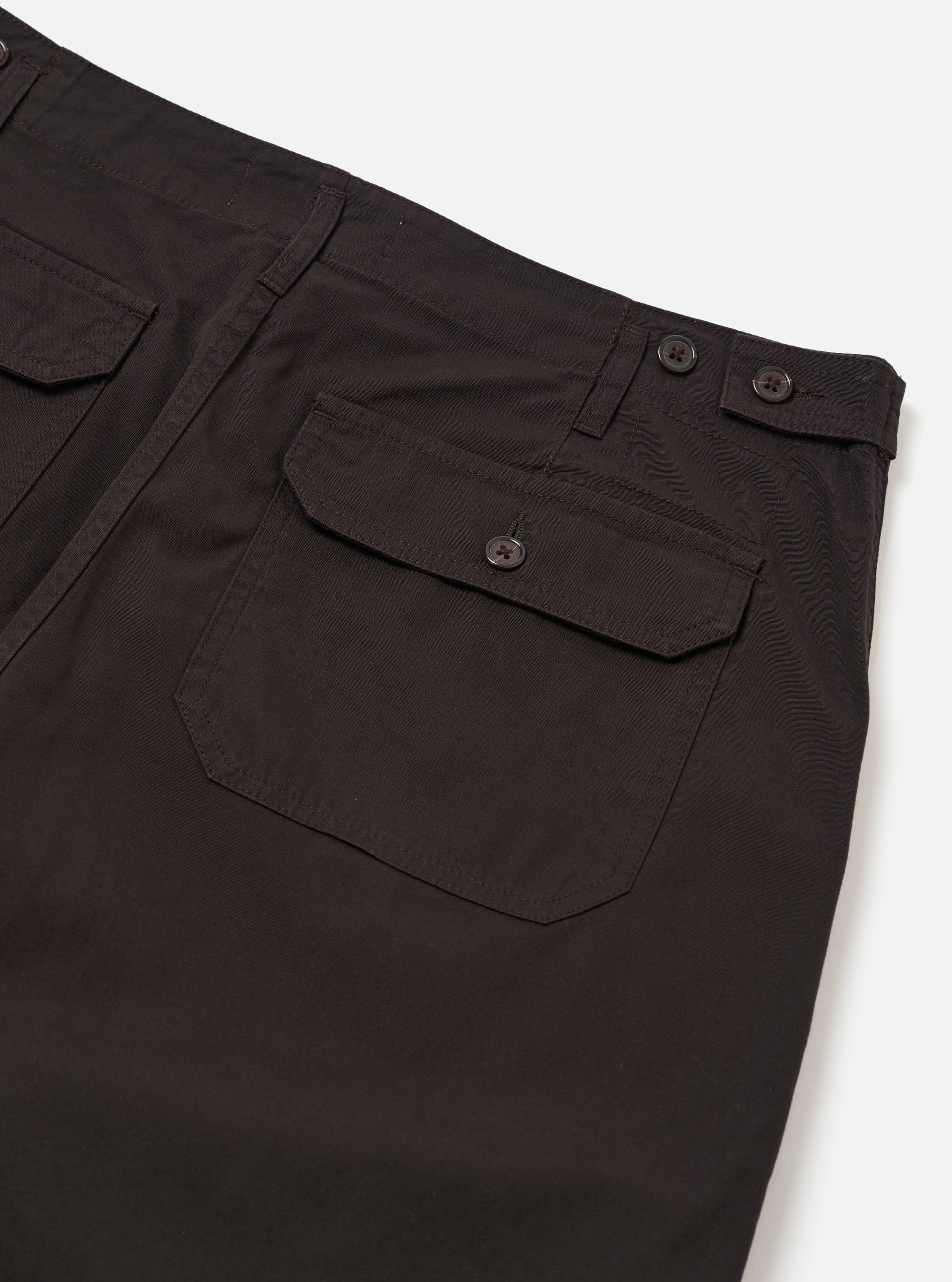 The Licorice Summer Canvas Clean Short is shown from the back as a flat lay against a plain white background. The image highlights the elasticated waistband and two large rear patch pockets. The cotton canvas fabric is a solid dark brown color.