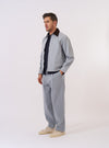 The Light Indigo Jean Cloth Reworked Rose Bowl Jacket is shown as a flat lay against a white background. The jacket features a boxy fit with a full-length silver double-ended zip front, a structured collar, and buttoned adjustable cuffs. One large patch pocket is visible on the chest, along with two side welt pockets. The light indigo fabric is made from a reworked jean cloth with visible panelled construction and tonal stitching.