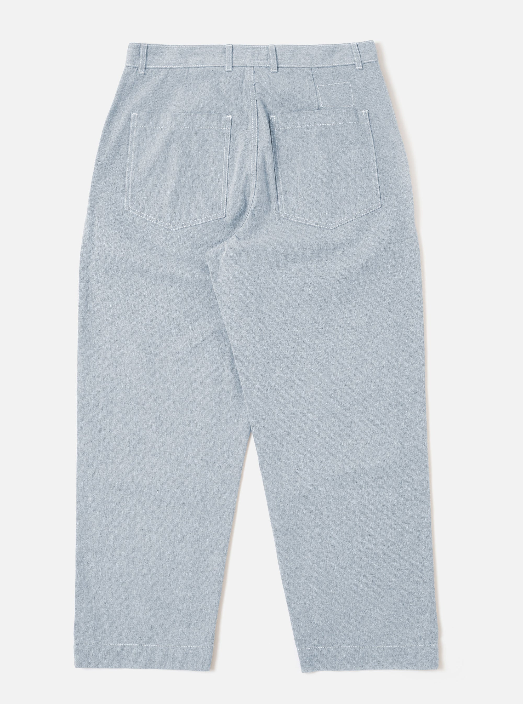 The Light Indigo Jean Cloth Reworked Duke Pant is shown from the back as a flat lay against a plain white background. The image highlights the two rear angled patch pockets, a fixed waistband, and the light indigo organic cotton fabric with a visible twill weave.