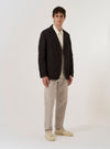 The Licorice Summer Canvas Two Button Jacket is shown as a flat lay against a plain white background. The jacket features a two-button front closure, notched lapels, two large patch pockets at the waist, and a single patch pocket on the left chest. The brown cotton fabric has a visible canvas texture.