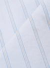 A close-up swatch image of the Soft Blue Mc Stripe Road Trip Shirt fabric displays a detailed view of the light blue and white vertical stripes. The textile has a visible woven texture with a fine grain, and the edges of the swatch are finished with a zigzag pinked cut.