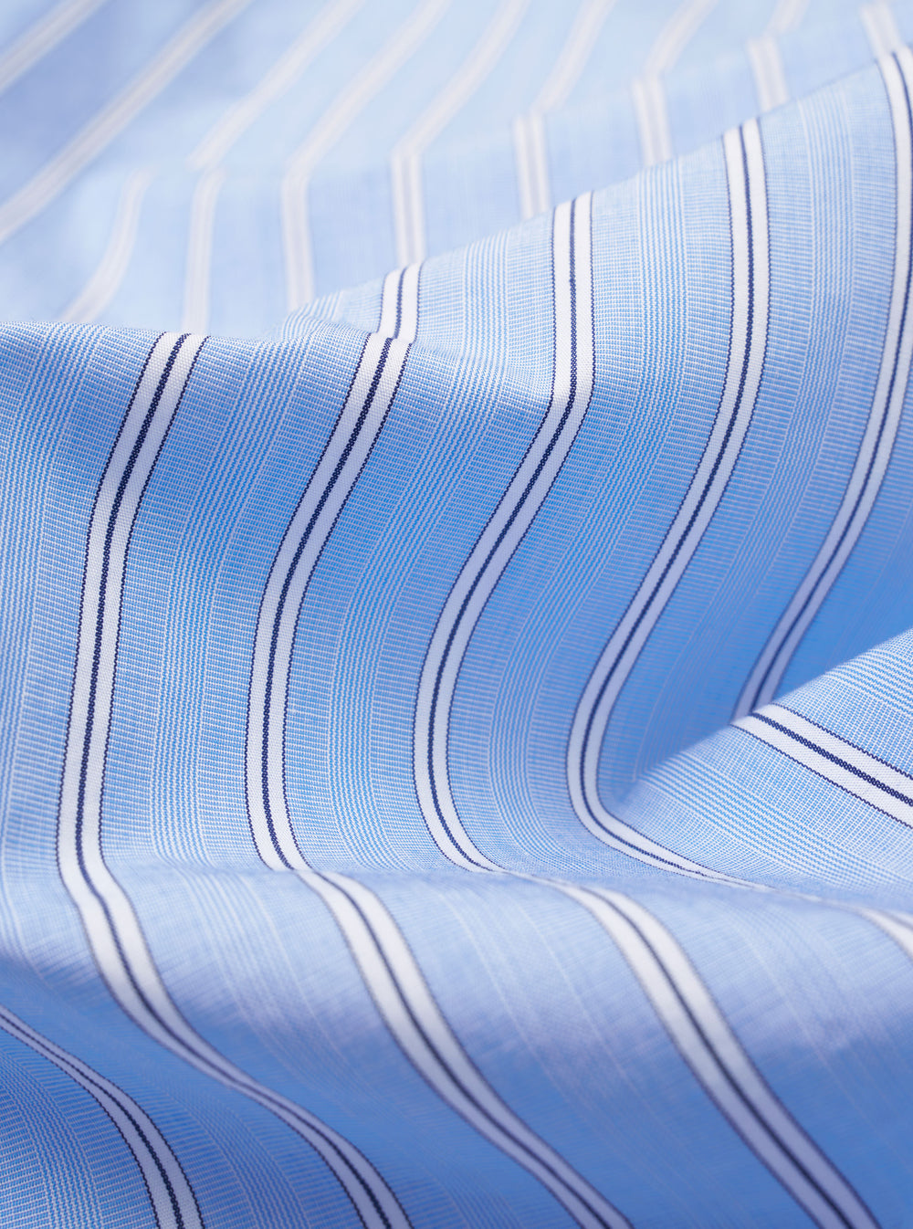 The Blue Mc Stripe Square Pocket Shirt is shown from a rear angle as a flat lay against a plain white background. The image highlights the shirt's back yoke, curved hem, and the fine vertical blue and white stripe pattern of the cotton fabric.