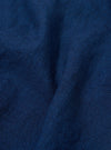 A close-up swatch image of the Indigo Lincot Denim Road Shirt fabric displays a deep indigo blue color with a visible diagonal twill weave and subtle white-flecked texture. The fabric appears midweight and structured.