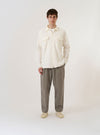 The Ecru Arten Seersucker Attendant Shirt is shown as a flat lay against a plain white background. The shirt features a central button-down front, a classic collar, and two large patch pockets at the waist. The ecru-colored organic cotton fabric has a distinct puckered seersucker texture.