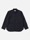 The Navy Tropical Suiting Travail Overshirt is shown as a flat lay against a white background. The garment features a single-piece collar, a button-through front, and two large patch pockets at the waist. It has adjustable button cuffs and a curved hem. The navy fabric is a lightweight tropical wool blend with a smooth, minimal appearance.