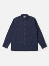 The Navy Seersucker Shirting Lucky Shirt is shown as a flat lay against a plain white background. The shirt features a central button-down front, a single patch pocket on the left chest, and a classic pointed collar. The fabric has a distinct puckered seersucker texture in a deep navy blue.