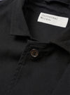 The Black Valencia Cotton Two Button Jacket is shown from the back as a flat lay against a plain white background. The image highlights the garment's rear construction, featuring a central vertical seam and a clean, straight hem. The black fabric appears smooth with a subtle technical finish.