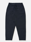 The Navy Valencia Cotton Pleated Track Pant is shown from the back as a flat lay against a plain white background. The image highlights the two rear pockets, including one with a buttoned flap and one button jetted pocket, and the elasticated waistband. The navy blue fabric has a fine, plain weave.