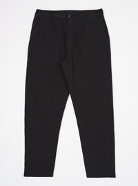 The Black Merida Seersucker Military Chino is shown as a flat lay against a white background. The trousers feature a high rise with a one-piece Hollywood waistband, slash front pockets, and a buttoned fly. The fabric has a distinct black puckered seersucker texture.