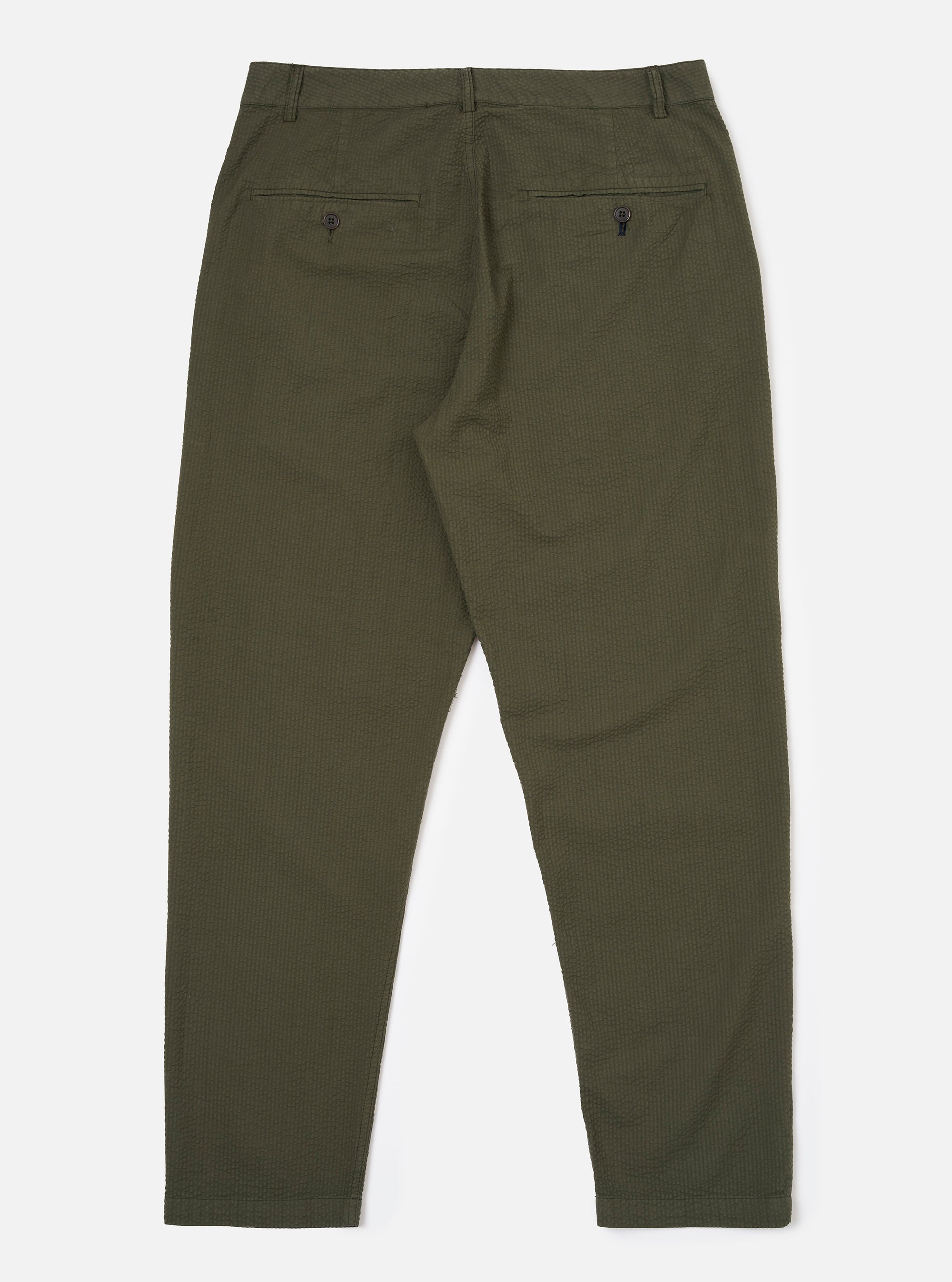 The Olive Merida Seersucker Military Chino is shown from the back as a flat lay against a plain white background. The image highlights the two rear pockets, including one with a button-down flap and one jetted, along with the elasticated portion of the waistband and the textured olive green seersucker fabric.