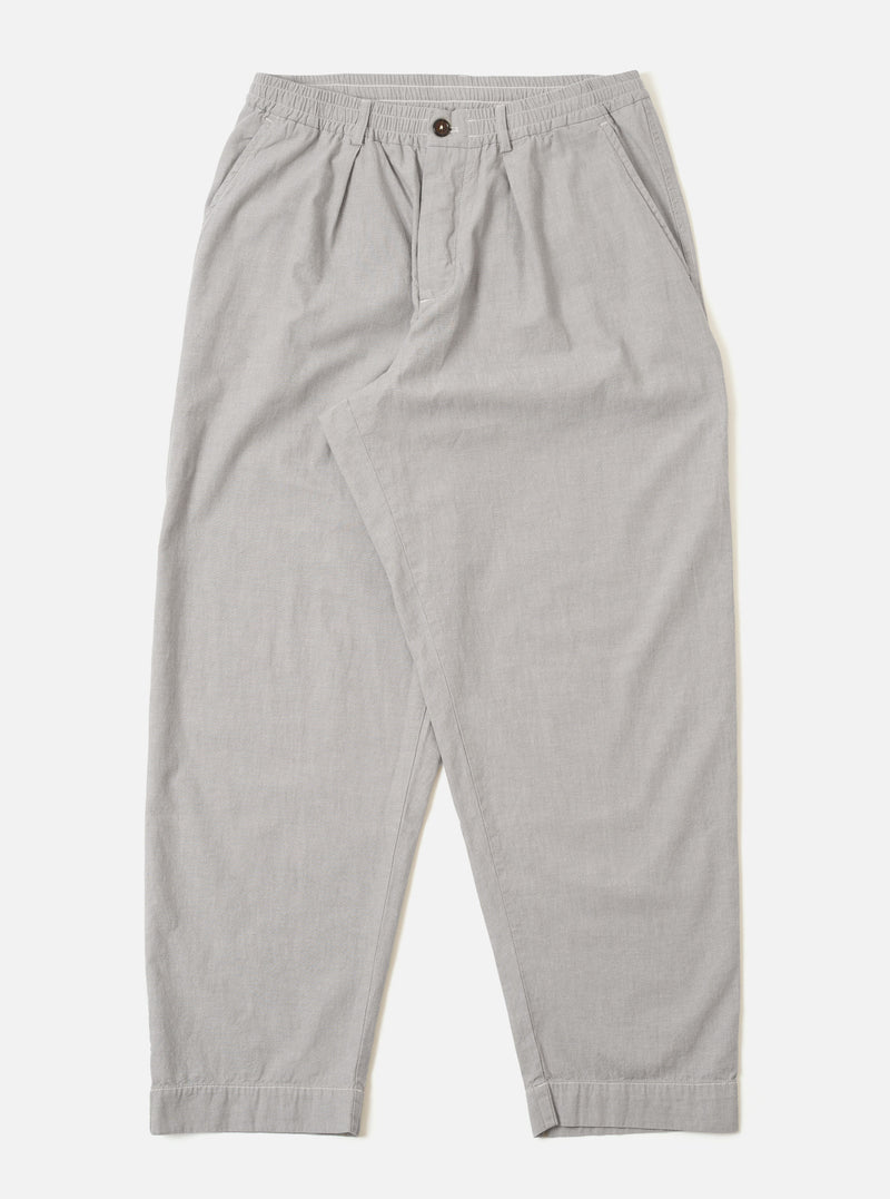 The Grey Izumi Cotton Oxford Pant is shown as a flat lay against a white background. The trousers feature a wide, loose leg with a single pleat at the front and an elasticated waistband with a drawstring. Two front pockets and a button fly are visible. The fabric is a solid grey cotton.
