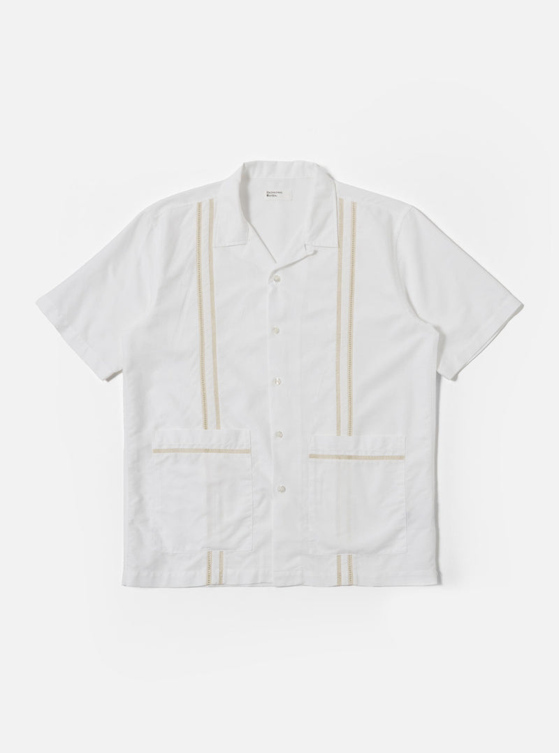 The White Classic Oxford Tropicana Shirt is shown as a flat lay against a white background. The shirt features a one-piece open collar, short loose sleeves, and two large patch pockets located at the lower front hip area. It has a center-front button closure and is made from a textured white Oxford cotton fabric.