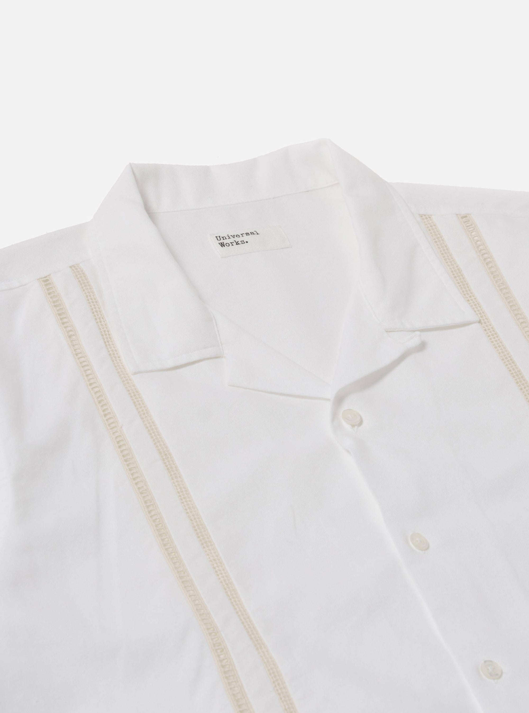 The White Classic Oxford Tropicana Shirt is shown from a back angle, worn by a model against a white background. The image highlights the shirt's short raglan sleeves with a small slit at the cuff and a straight hem. The model has their hands in their trouser pockets, showcasing the shirt's relaxed fit and soft Oxford cotton texture.