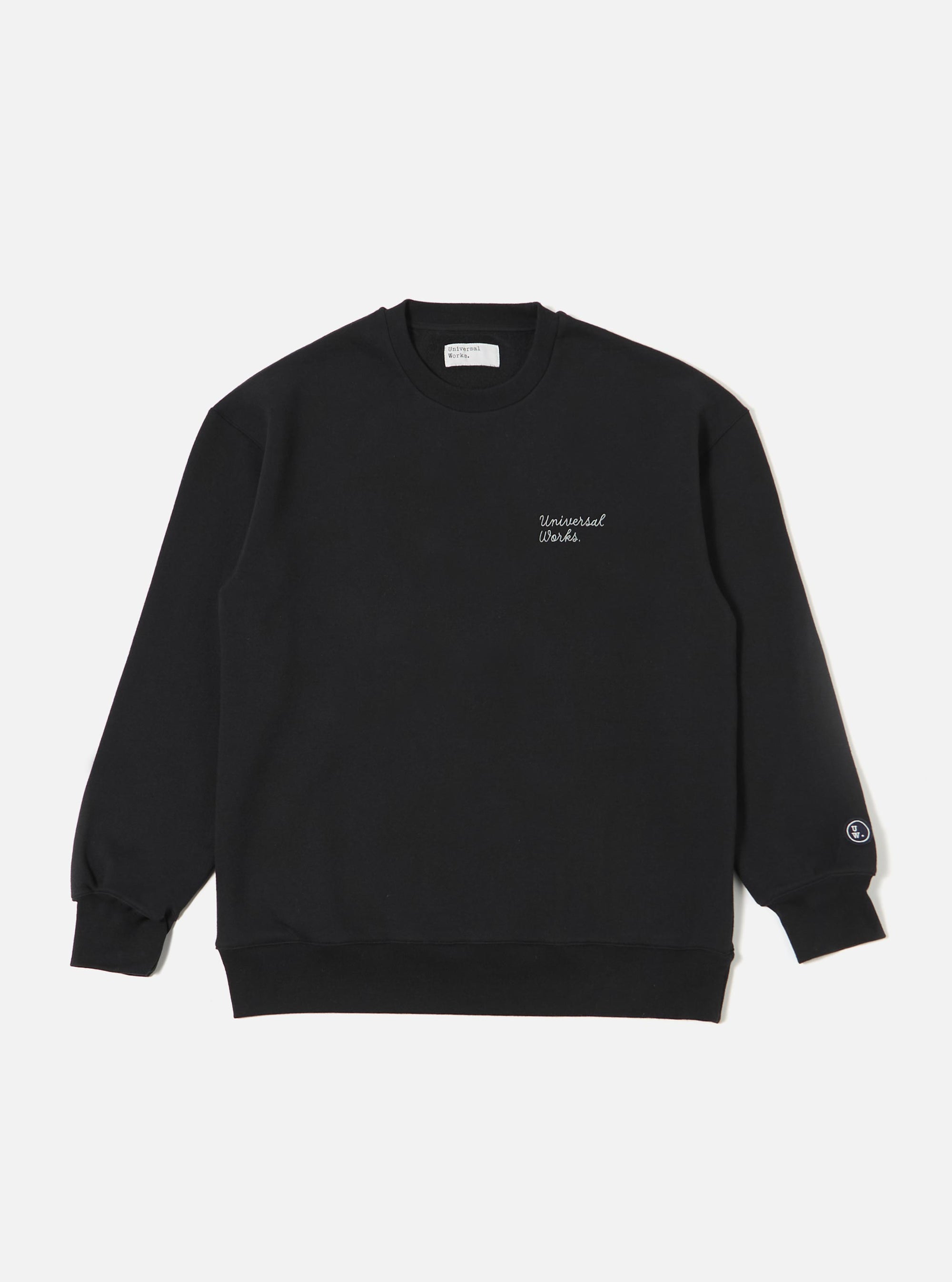The Black Recycled Cotton Blend Jersey Loose Sweatshirt is shown as a flat lay against a plain white background. The sweatshirt features a classic crew neckline, long sleeves with ribbed cuffs, and a ribbed hem. The garment has a relaxed, loose fit and is made from a smooth black jersey fabric.