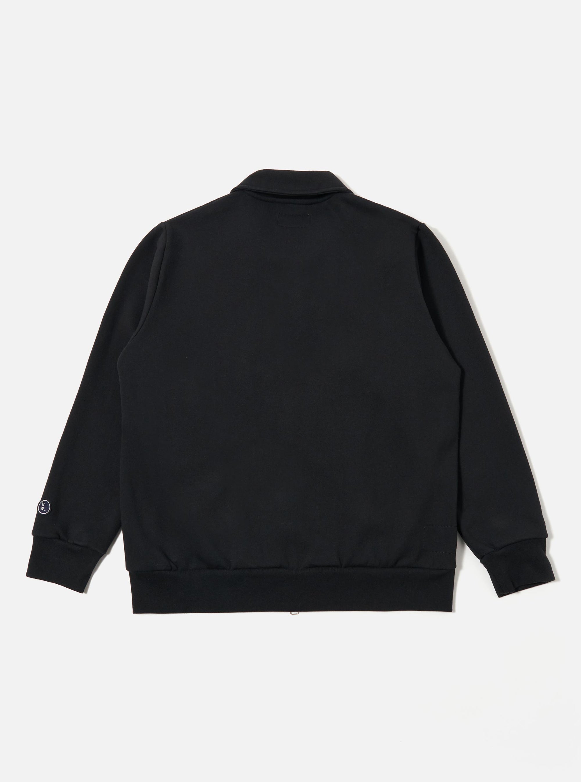 The Black Recycled Cotton Blend Jersey Tyler Jacket is shown from the back as a flat lay against a plain white background. The image highlights the jacket's simple construction, featuring a self-fabric collar and ribbed detailing at the cuffs and hem. The black jersey fabric appears smooth and consistent throughout the rear panel.