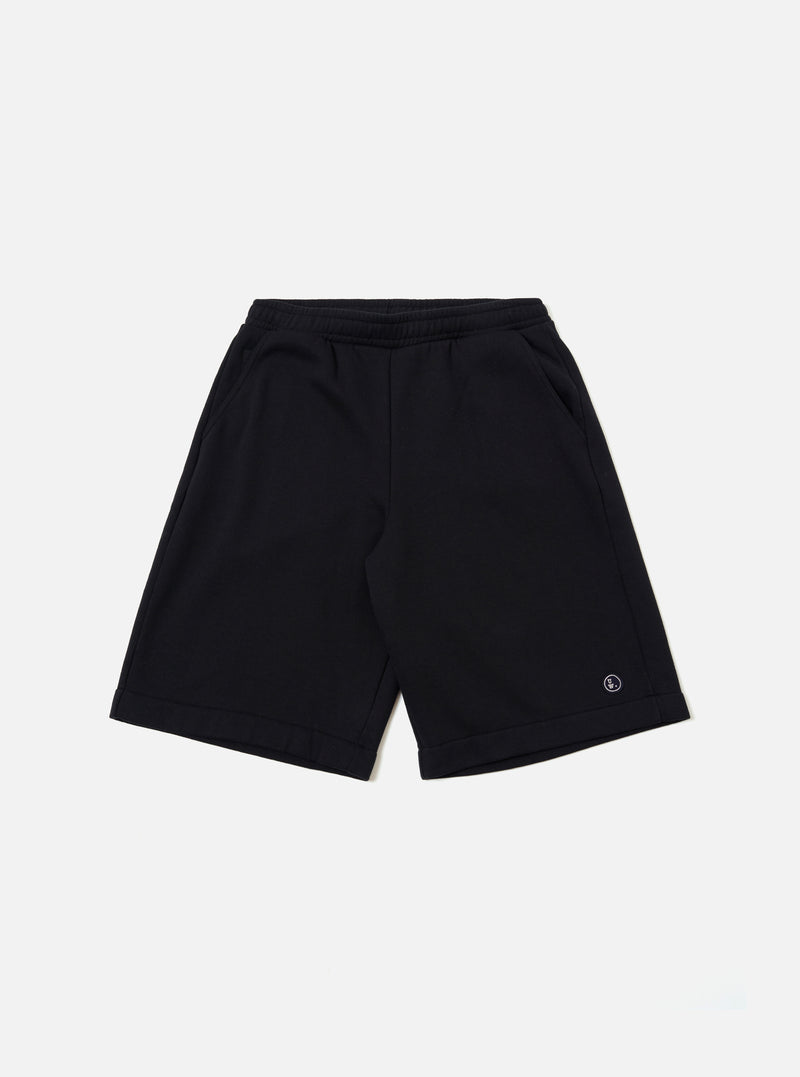The Black Recycled Cotton Blend Jersey Vacation Short is shown as a flat lay against a plain white background. The shorts feature an elasticated waistband with a matching drawstring and two large patch pockets on the front. The black jersey fabric has a soft, matte finish.