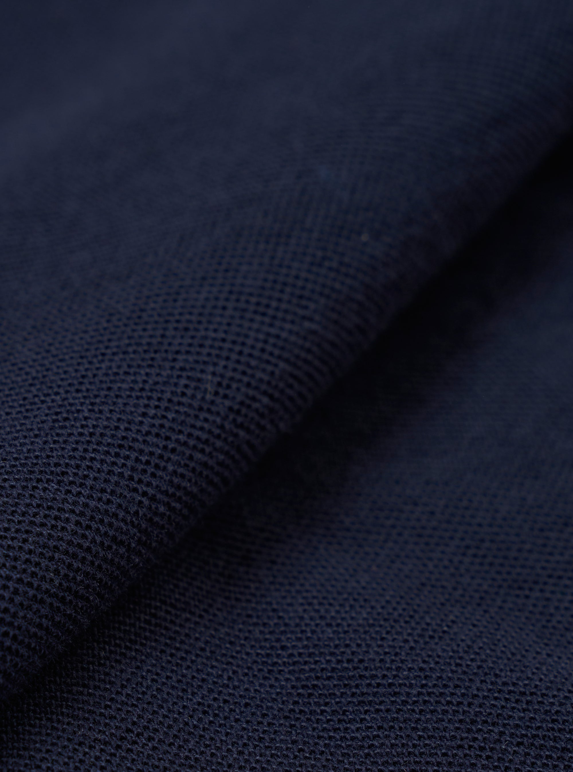 A close-up swatch image of the Bright Navy Piquet Vacation Polo shows the detailed texture of the navy blue piquet cotton fabric. The weave of the material is clearly visible, and