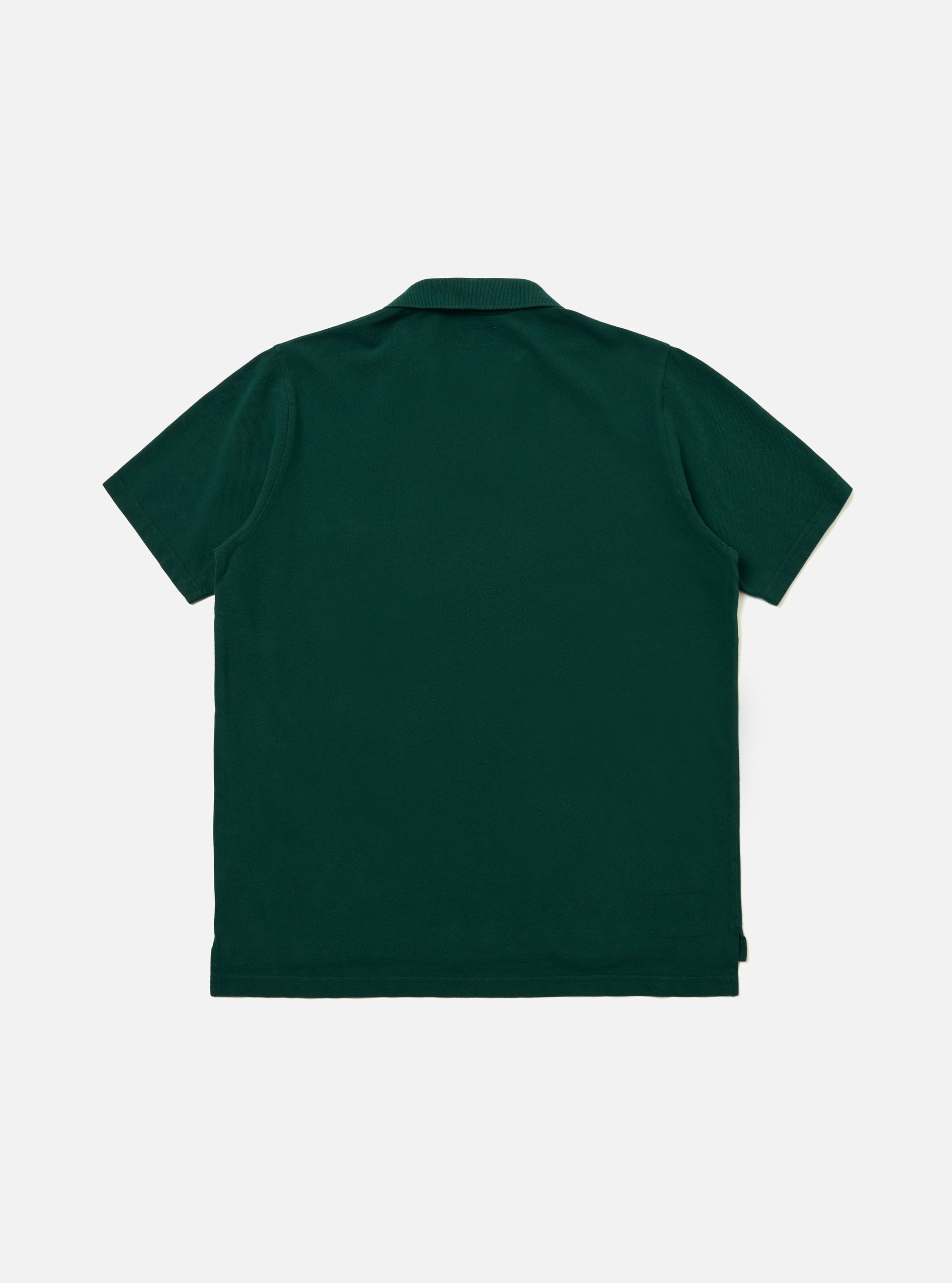 The Green Piquet Vacation Polo is shown from the back as a flat lay against a plain white background. The image highlights the garment's textured green piquet fabric, straight hem, and clean back panel construction.