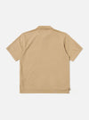 The Sand Rugby Jersey Oversized Vacation Polo is shown from the back as a flat lay against a plain white background. The polo features an oversized silhouette with dropped shoulders and short sleeves. The image highlights the smooth, solid sand-colored jersey fabric and clean stitching at the hem.