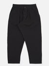 The Black Merida Seersucker Pleated Track Pant is shown as a flat lay against a white background. The trousers feature an elasticated waistband with a central drawstring, a single pleat on each leg, and two side pockets. The black cotton fabric has a distinct puckered seersucker texture.
