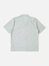 The Green Seersucker Road Shirt is shown from a rear angle on a model. The shirt features a straight hem and short sleeves, with the textured seersucker fabric being prominent. The model is standing against a plain, light grey background. No mannequin is present in the image.