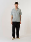 The Green Seersucker Road Shirt is shown as a flat lay against a plain white background. The shirt features a camp collar, a button-front closure, and a single chest patch pocket. The fabric has a distinct puckered seersucker texture in a solid green color.