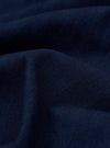 A close-up swatch image of the Indigo Recycled Herringbone Attendant Shirt fabric displays a deep indigo blue color with a distinct herringbone weave pattern. The texture of the recycled cotton fabric is prominently visible.
