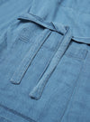 The Washed Indigo Recycled Herringbone Kyoto Work Jacket is shown from the back as a flat lay against a plain white background. The image highlights the jacket's straight hem, loose fit, and the distinct chevron pattern of the washed indigo herringbone fabric.