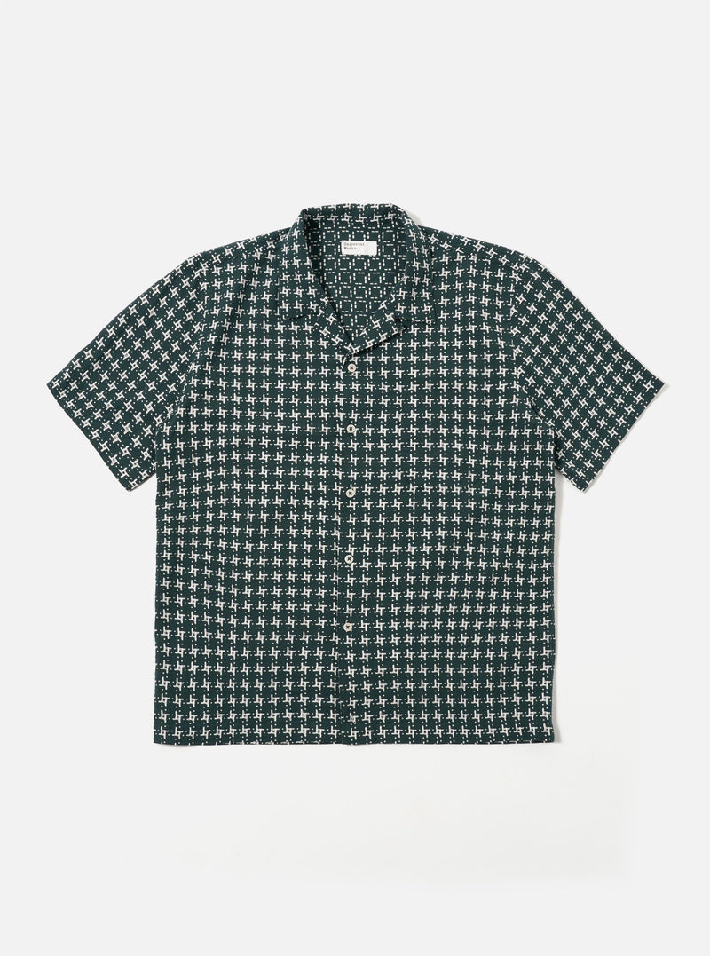 The Green/White Rhodes 8 Cotton Road Shirt is shown as a flat lay against a white background. The shirt features an all-over vertical stripe pattern in green and white, a camp collar, a central button-down closure, and two large chest patch pockets. The fabric has a visible textured weave.