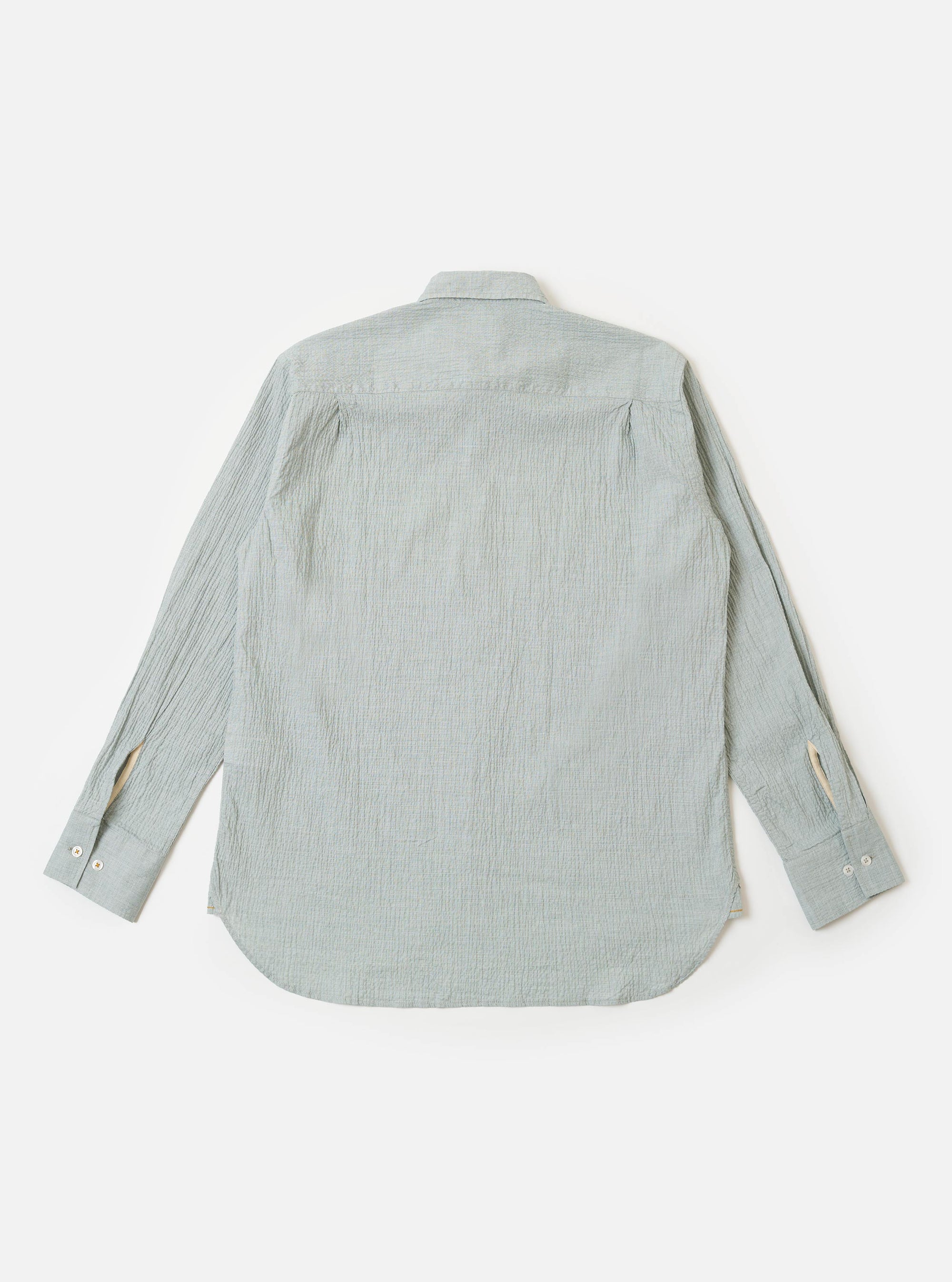 The Green Seersucker Square Pocket Shirt is shown from the back as a flat lay against a plain white background. The image highlights the shirt's textured green seersucker fabric, a straight hem, and a simple one-piece back panel with a central box pleat.