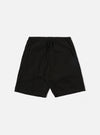 The Black Kelly Cotton Simple Short is shown as a flat lay against a white background. The shorts feature an elasticated waistband with a drawstring, two slanted side pockets, and a single rear patch pocket. The fabric is a solid black cotton with a slight texture.